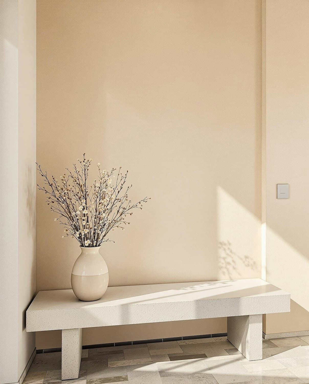 Sunlit, spotless entryway with a modern bench and a vase of white flowers